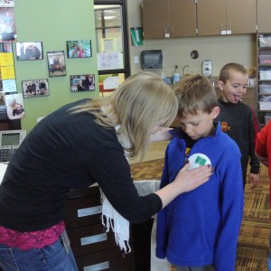 First grade teacher puts sticker on student